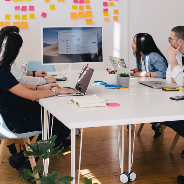 Coworkers discuss financial reports at office table